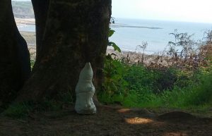 Gnome reading on Langland Bay coastal path