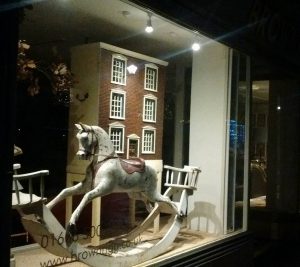 Rocking horse and doll's house in an antique shop Christmas window display