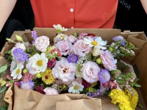 A wedding centrepiece of assorted blooms in yellow, white, pink, and purple